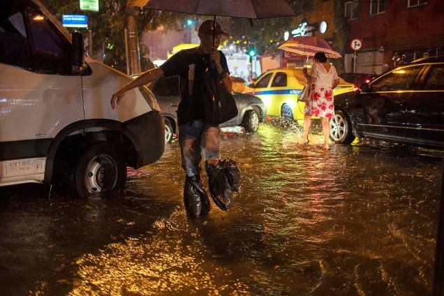 Pedestres atravessam enchente na rua Mena Barreto, no bairro do Botafogo, localizado no Rio de Janeiro (RJ) - 08/04/2019 Pedestres atravessam enchente na rua Mena Barreto, no bairro do Botafogo, localizado no Rio de Janeiro (RJ) - 08/04/2019