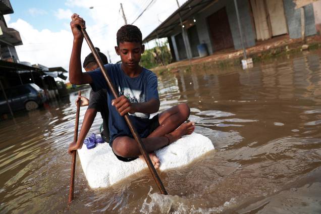 Crianças remam em bloco de isopor, após forte temporal atingir o bairro de Guaratiba, no Rio de Janeiro (RJ) - 10/04/2019 Crianças remam em bloco de isopor, após forte temporal atingir o bairro de Guaratiba, no Rio de Janeiro (RJ) - 10/04/2019