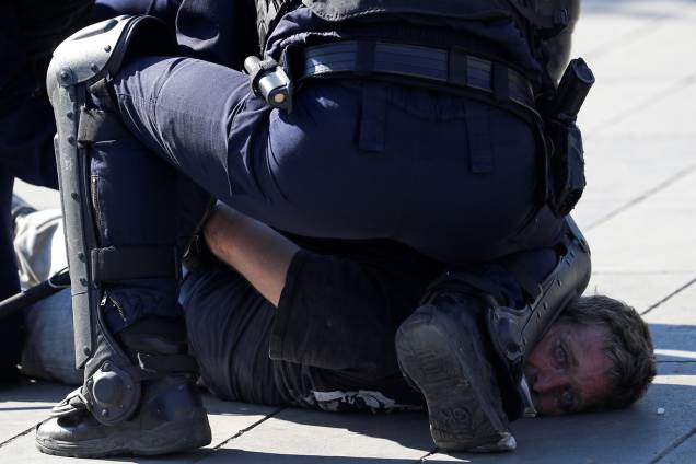 Policial detém um manifestante durante um protesto dos Coletes Amarelos em Paris, na França - 20/04/2019 Policial detém um manifestante durante um protesto dos Coletes Amarelos em Paris, na França - 20/04/2019