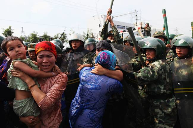 Uigur, China Policiais chineses empurram mulheres da etnia uigur durante protesto em Urumqi, capital da região autônoma de Xinjiang – 07/07/2009
