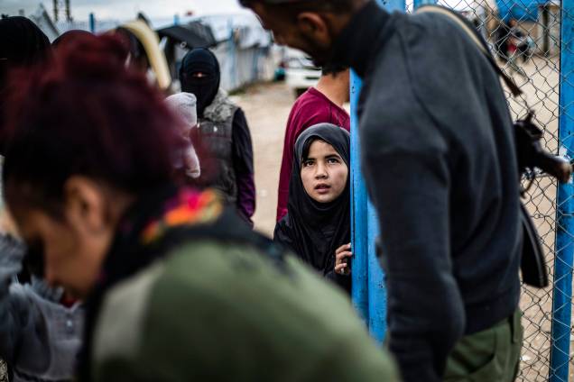 Membro das Forças Democráticas da Síria (SDF) abre porta para uma menina no campo de Al-Hol Membro das Forças Democráticas da Síria (SDF) abre porta para uma menina no campo de Al-Hol