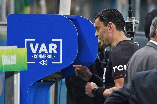 O árbitro chileno Roberto Tobar Vargas checa o VAR durante partida entre Brasil e Paraguai - 27/06/2019 O árbitro chileno Roberto Tobar Vargas checa o VAR durante partida entre Brasil e Paraguai - 27/06/2019