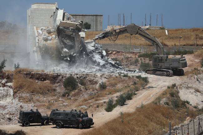 Israeli military machinery demolishes a Palestinian building in the village of Sur Baher which sits on either side of the Israeli barrier in East Jerusalem and the Israeli-occupied West Bank Israeli military machinery demolishes a Palestinian building in the village of Sur Baher which sits on either side of the Israeli barrier in East Jerusalem and the Israeli-occupied West Bank