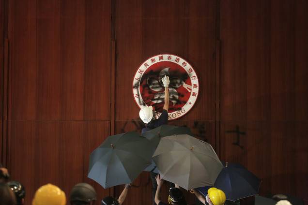 Manifestante picha emblema de Hong Kong durante invasão no prédio do Conselho Legislativo do país, em Hong Kong - 01/07/2019 Manifestante picha emblema de Hong Kong durante invasão no prédio do Conselho Legislativo do país, em Hong Kong - 01/07/2019
