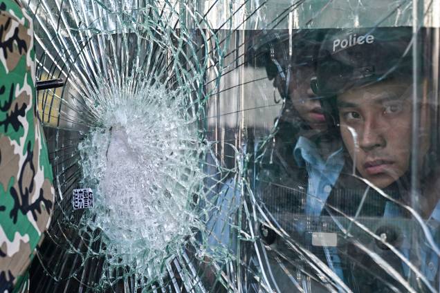 A polícia que está dentro do quartel-general do governo observa os manifestantes que tentaram invadir o prédio durante o aniversário da transferência de Hong Kong para a China, em Hong Kong - 01/07/2019 A polícia que está dentro do quartel-general do governo observa os manifestantes que tentaram invadir o prédio durante o aniversário da transferência de Hong Kong para a China, em Hong Kong - 01/07/2019