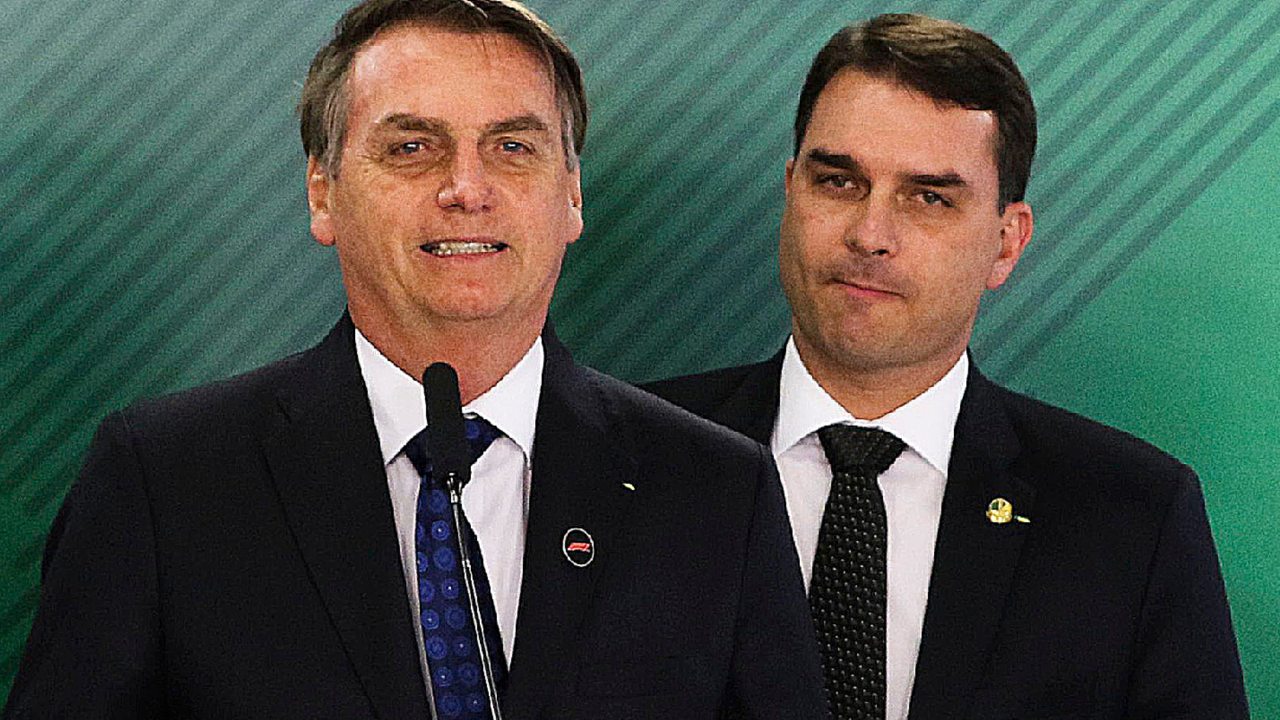 O presidente da República, Jair Bolsonaro, com o filho Flávio, que é senador, em cerimônia no Palácio do Planalto - 24/06/2019