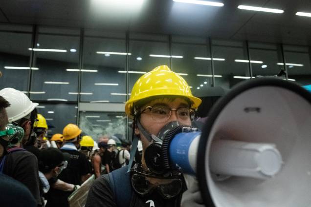 Manifestante usa um megafone enquanto outros quebram as portas e janelas de vidro da sede do governo em Hong Kong, no 22º aniversário da transferência da cidade da Grã-Bretanha para a China - 01/07/2019 Manifestante usa um megafone enquanto outros quebram as portas e janelas de vidro da sede do governo em Hong Kong, no 22º aniversário da transferência da cidade da Grã-Bretanha para a China - 01/07/2019