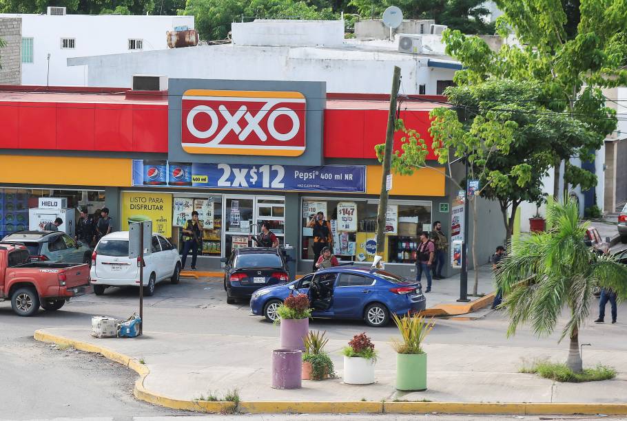 Homens armados à frente de uma loja durante confrontos entre o Cartel de Sinaloa e as autoridades em Cualitán - 17/10/2019