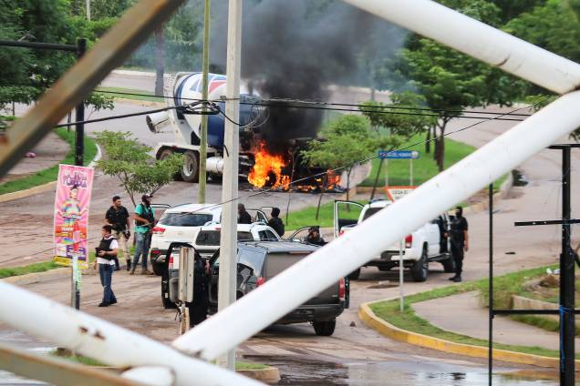 Homens armados próximos a um caminhão em chamas durante confrontos com as autoridades após a apreensão de Ovidio Guzmán, filho de El Chapo, em Culiacán - 17/10/2019 Homens armados próximos a um caminhão em chamas durante confrontos com as autoridades após a apreensão de Ovidio Guzmán, filho de El Chapo, em Culiacán - 17/10/2019
