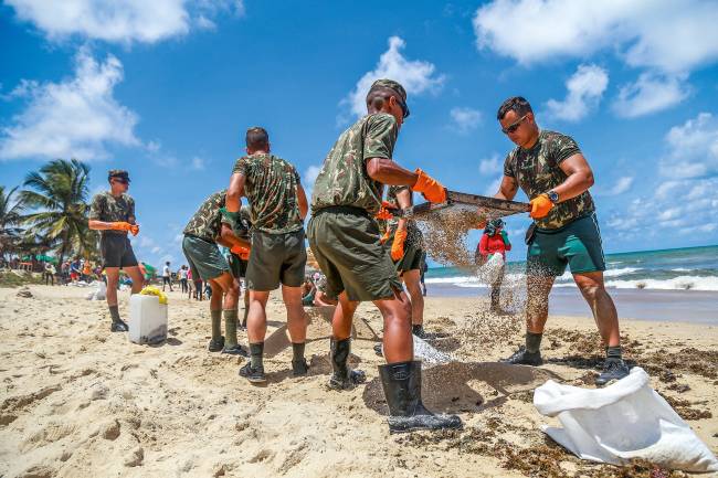 Brazilian army soldiers work to remove an oil spill on Itapuama Beach in Cabo de Santo Agostinho