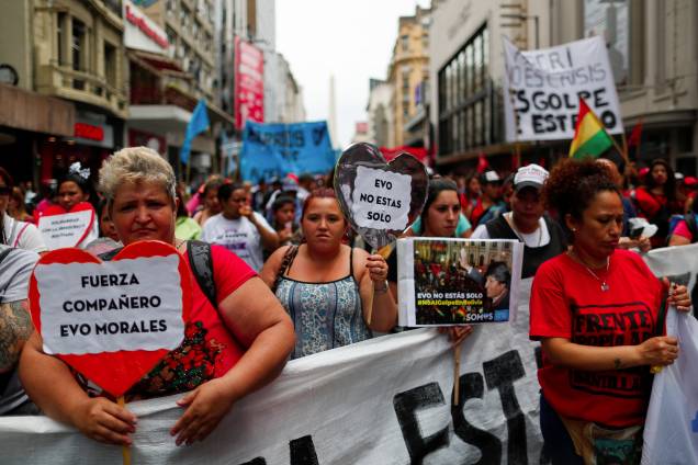 Pessoas segurando cartazes lendo "Força companheiro Evo Morales" e "Você não está sozinho" participam de uma manifestação em apoio ao presidente boliviano Evo Morales depois que ele anunciou sua renúncia no domingo, em Buenos Aires, Argentina. Pessoas segurando cartazes lendo "Força companheiro Evo Morales" e "Você não está sozinho" participam de uma manifestação em apoio ao presidente boliviano Evo Morales depois que ele anunciou sua renúncia no domingo, em Buenos Aires, Argentina.