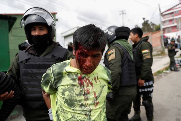 Um policial detém um homem ferido durante os confrontos entre partidários do presidente boliviano Evo Morales, e partidários da oposição, em La Paz. Um policial detém um homem ferido durante os confrontos entre partidários do presidente boliviano Evo Morales, e partidários da oposição, em La Paz.