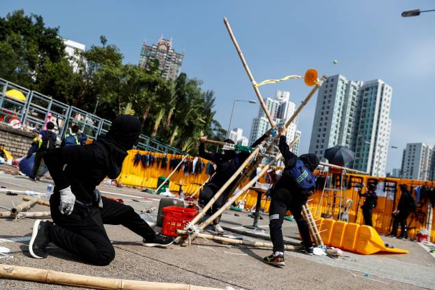 Manifestantes estudantis usam um estilingue gigante improvisado para arremessar bolas de tênis através de uma barricada como lazer na Universidade Batista de Hong Kong, China Manifestantes estudantis usam um estilingue gigante improvisado para arremessar bolas de tênis através de uma barricada como lazer na Universidade Batista de Hong Kong, China