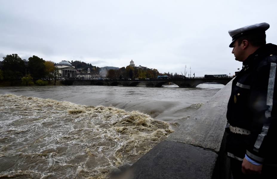 A man watches as Italy's longest river, river Po, has reached a critical level as torrential rain sweeps Italy flooding parts of Turin's city centre, in Turin, Italy — 24/11/2019