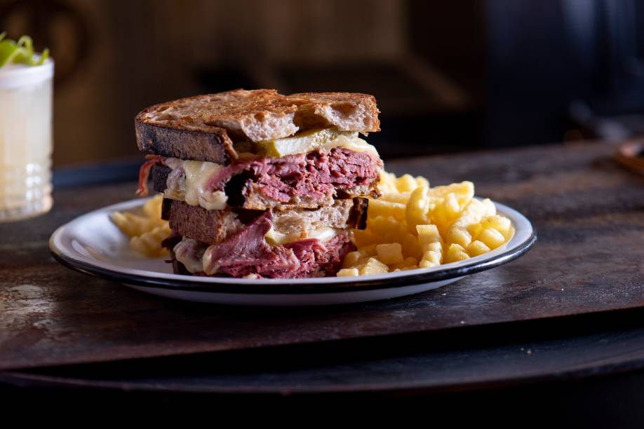 Sanduíche de pastrami feito na casa: acompanhado de mussarela, picles e mostarda, montado no pão de fermentação natural