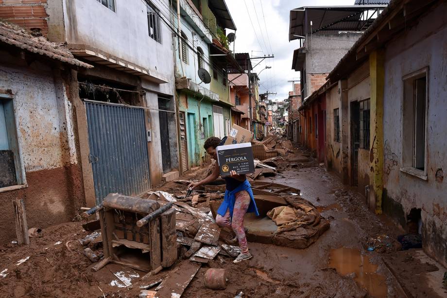 Um morador local caminha entre escombros após o transbordamento do córrego Da Prata devido a chuvas torrenciais, em Raposos, região metropolitana de Belo Horizonte, em 28 de janeiro