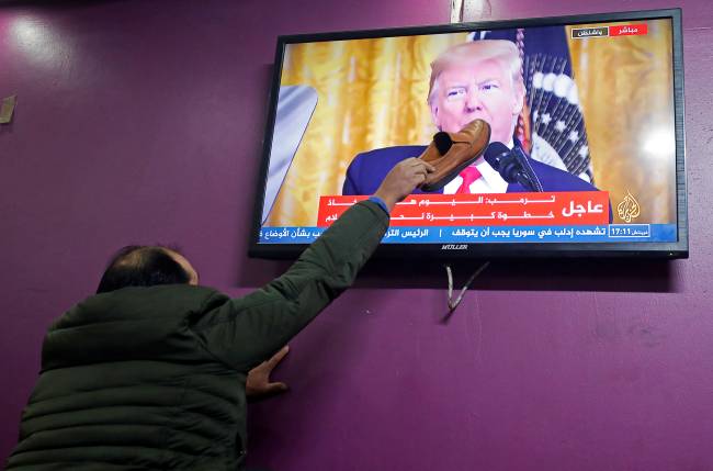 Um homem palestino coloca um sapato na boca de Trump Um homem palestino coloca um sapato na boca de Trump