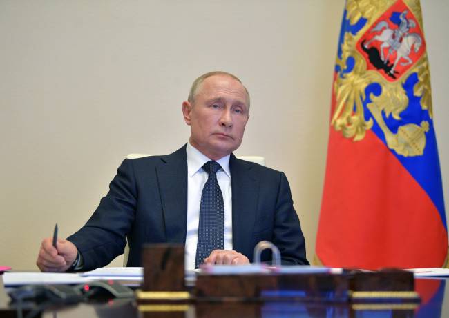 Russian President Vladimir Putin chairs a meeting via a video link outside Moscow