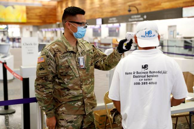 FILE PHOTO: A Hawaii National Guardsman checks the temperature of a traveler at the Daniel K. Inouye International Airport during the spread of the coronavirus disease (COVID-19) in Honolulu FILE PHOTO: A Hawaii National Guardsman checks the temperature of a traveler at the Daniel K. Inouye International Airport during the spread of the coronavirus disease (COVID-19) in Honolulu