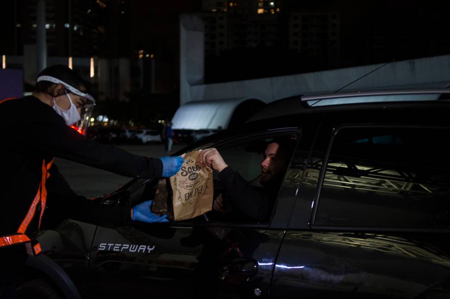 Primeiro, passam por um stand e sem sair do carro recebem o seu "kit alimentação"