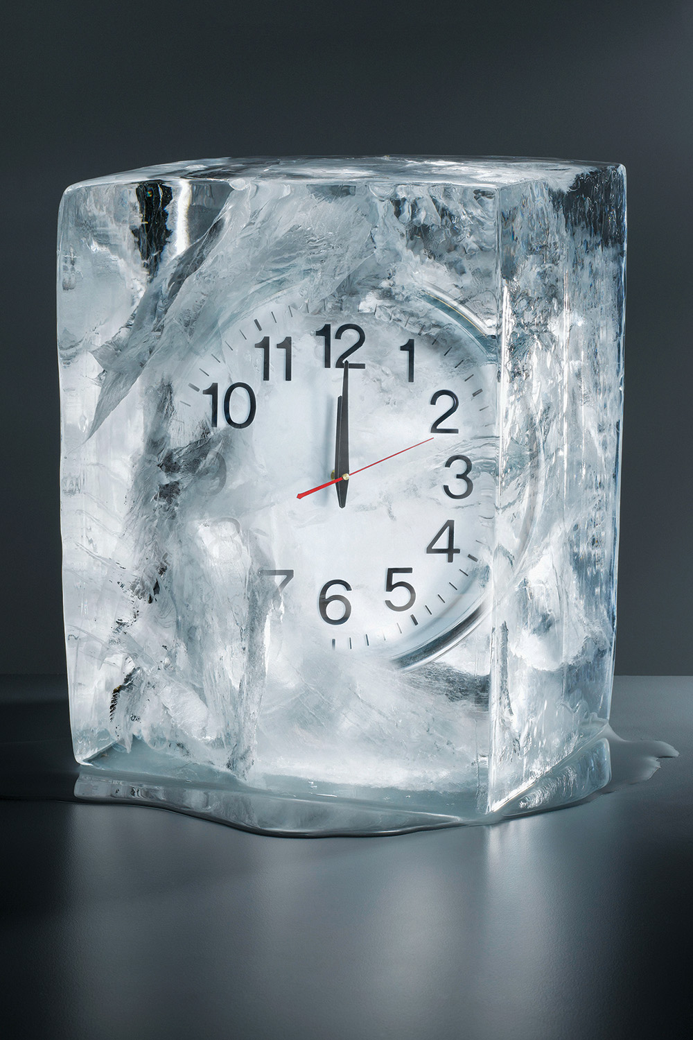 Alarm clock frozen in ice, close-up Alarm clock frozen in ice, close-up