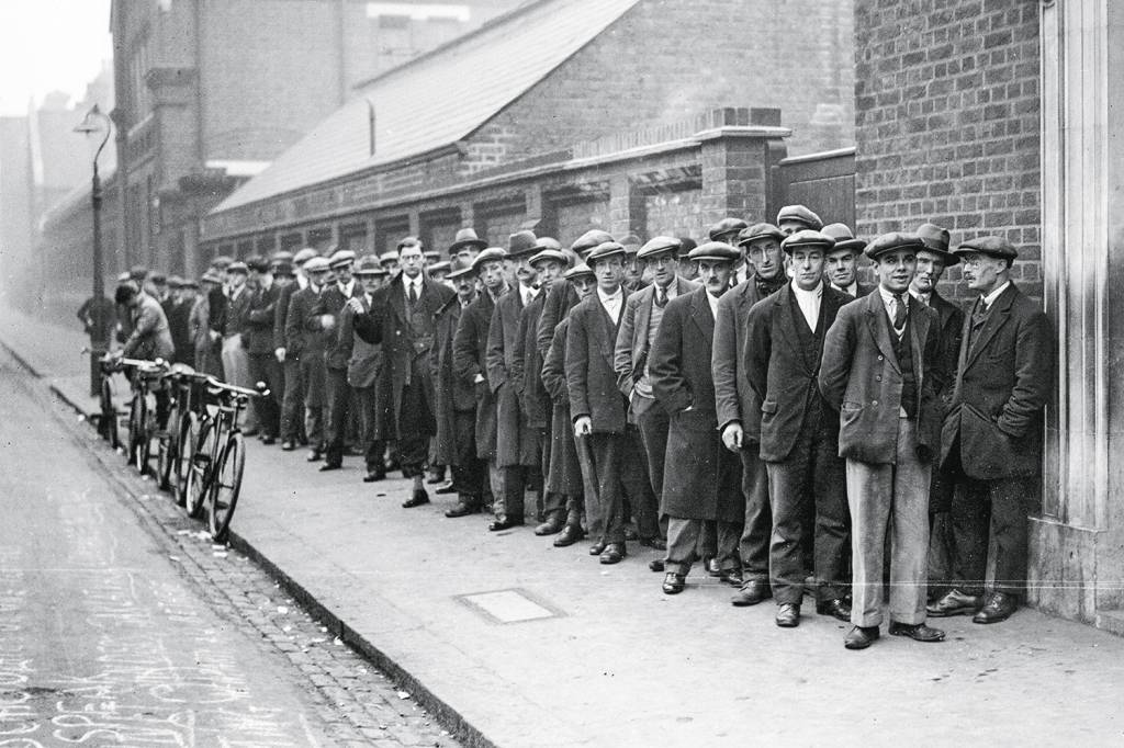 Unemployed men queuing at a labour exchange, October 1931. 1929 - Na fila do emprego: nos EUA, a Grande Depressão levou a inovações como o salário mínimo -