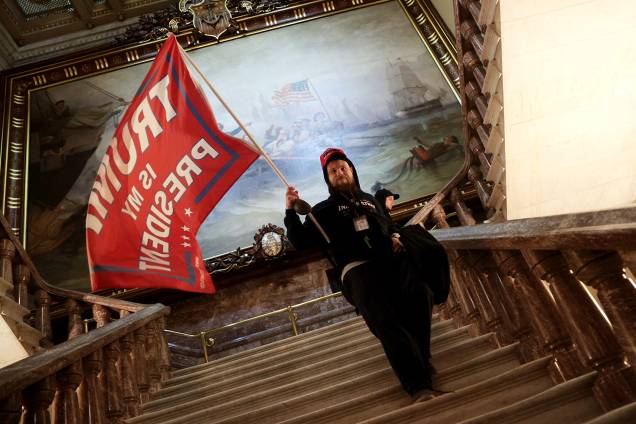 Um manifestante segura uma bandeira pró-Trump dentro do edifício do Capitólio, nos EUA - Um manifestante segura uma bandeira pró-Trump dentro do edifício do Capitólio, nos EUA -