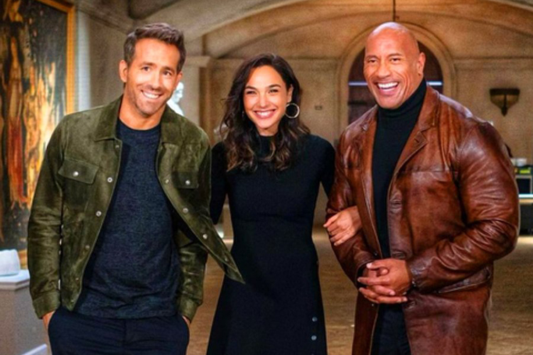 Cena de vídeo anunciado pela Netflix, com Ryan Reynolds, Gal Gadot e Dwayne Johnson, protagonistas do original 'Red Notice'