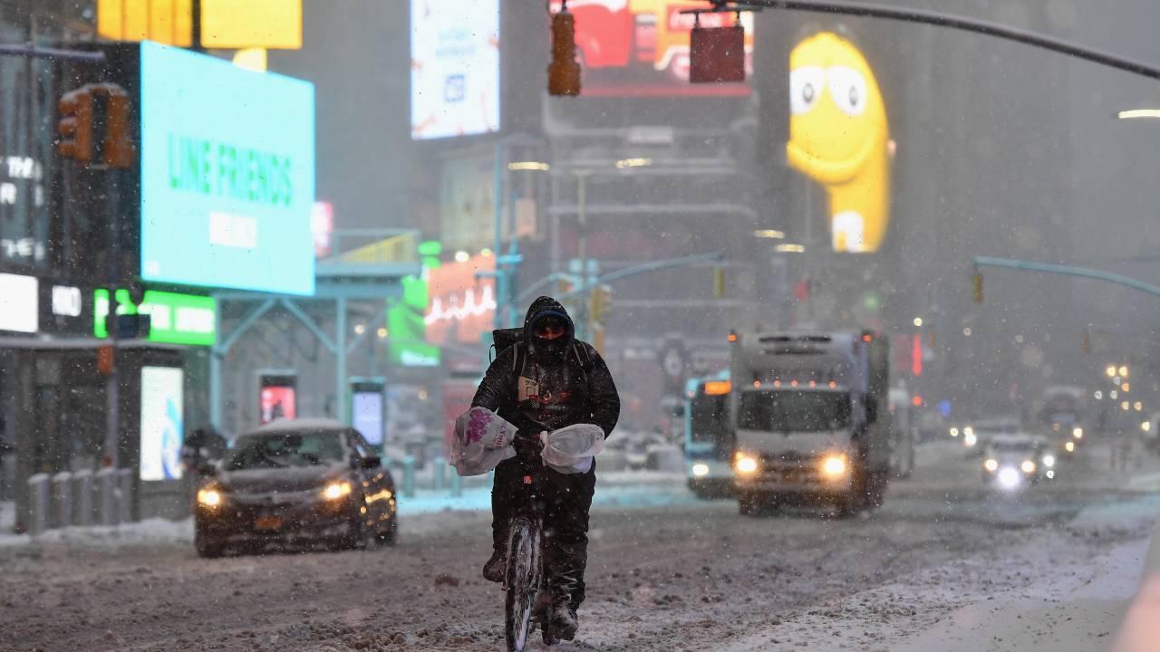 Uma pessoa anda de bicicleta na Times Square durante uma tempestade de inverno em 1º de fevereiro de 2021 na cidade de Nova York. - Uma poderosa tempestade de inverno está definida para despejar pés de neve ao longo de um trecho da costa leste dos Estados Unidos, incluindo a cidade de Nova York, em 1º de fevereiro de 2021, após cobrir a capital do país.