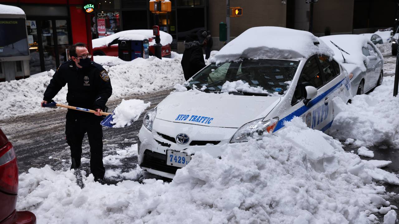 Policial retira neve de viatura em Manhattan, Nova York. 02/02/2021