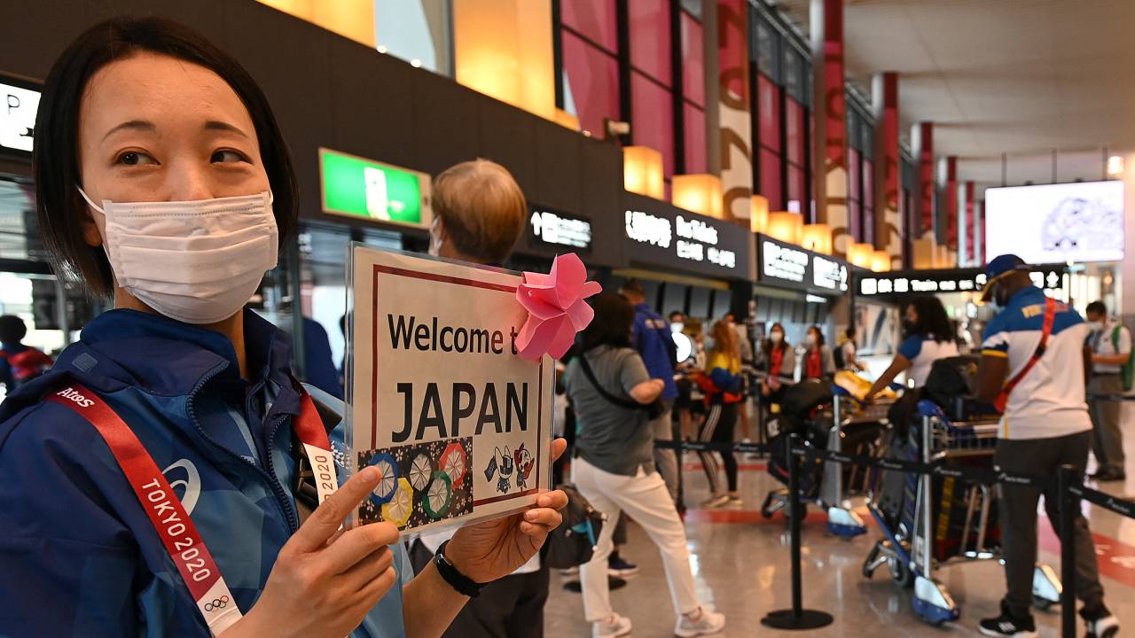 A volunteer staff welcomes the Olympic delegation at Narita International Airport in Narita, Chiba prefecture on July 20, 2021 to take part of the upcoming Tokyo 2020 Olympic Games. (Photo by Kazuhiro NOGI / AFP)