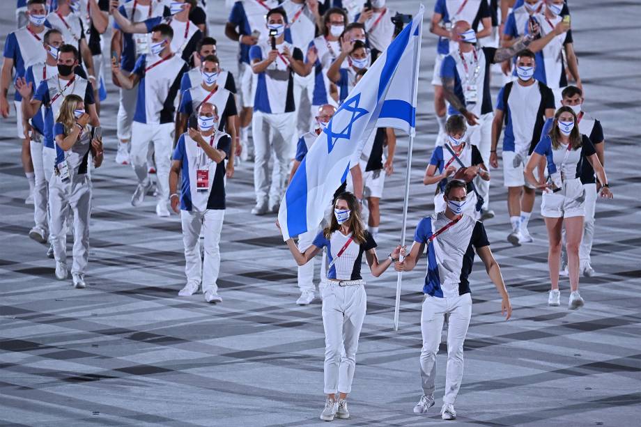 Hanna Minenko e Yakov Toumarkin carregam a bandeira de Israel e lideram a delegação na cerimônia de abertura dos Jogos Olímpicos de Tóquio, no Estádio Olímpico -