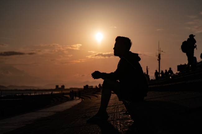 Tsuyoshi Yamaguchi observa o pôr do sol na praia de Kugenuma -