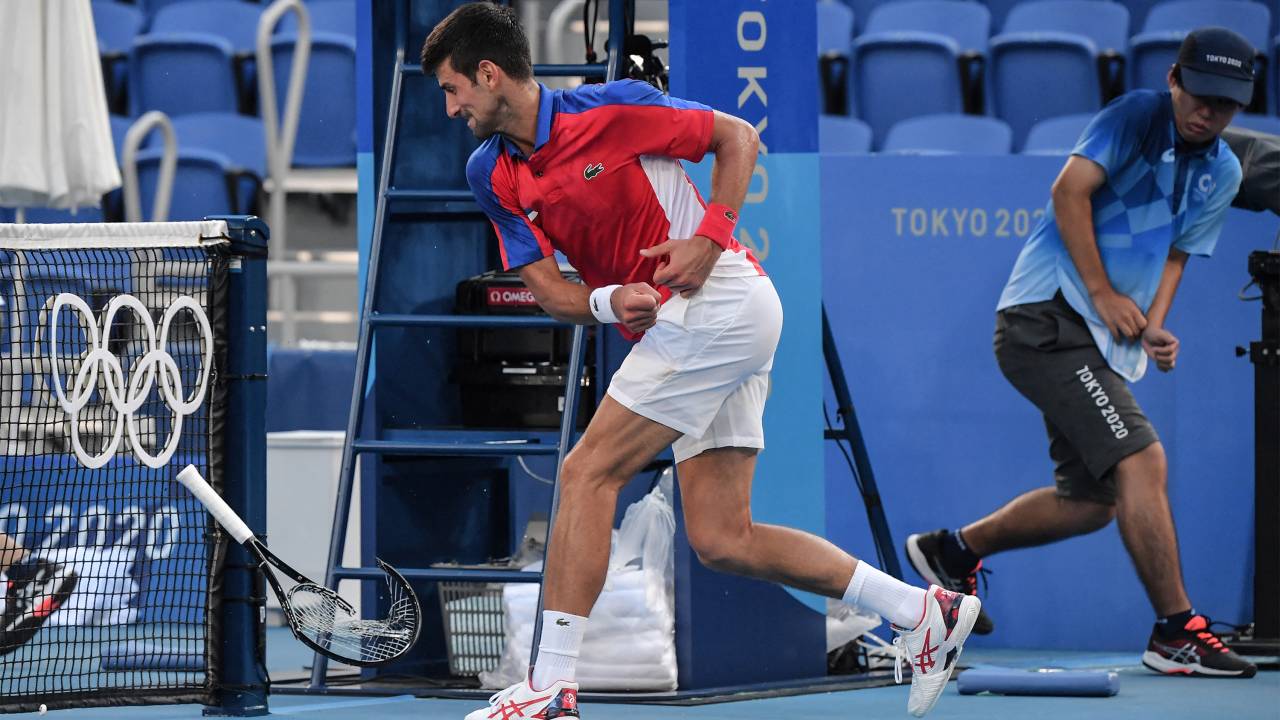 Serbia's Novak Djokovic smashes his racket during his Tokyo 2020 Olympic Games men's singles tennis match for the bronze medal against Spain's Pablo Carreno Busta at the Ariake Tennis Park in Tokyo on July 31, 2021. (Photo by Tiziana FABI / AFP)