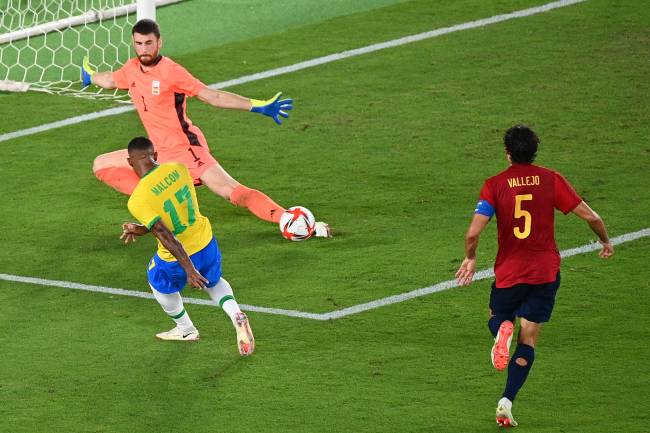 Brazil's Malcom Filipe scores past Spain's goalkeeper Unai Simon during the Tokyo 2020 Olympic Games football competition men's gold medal match at Yokohama International Stadium in Yokohama, Japan, on August 7, 2021. (Photo by Vincenzo PINTO / AFP)