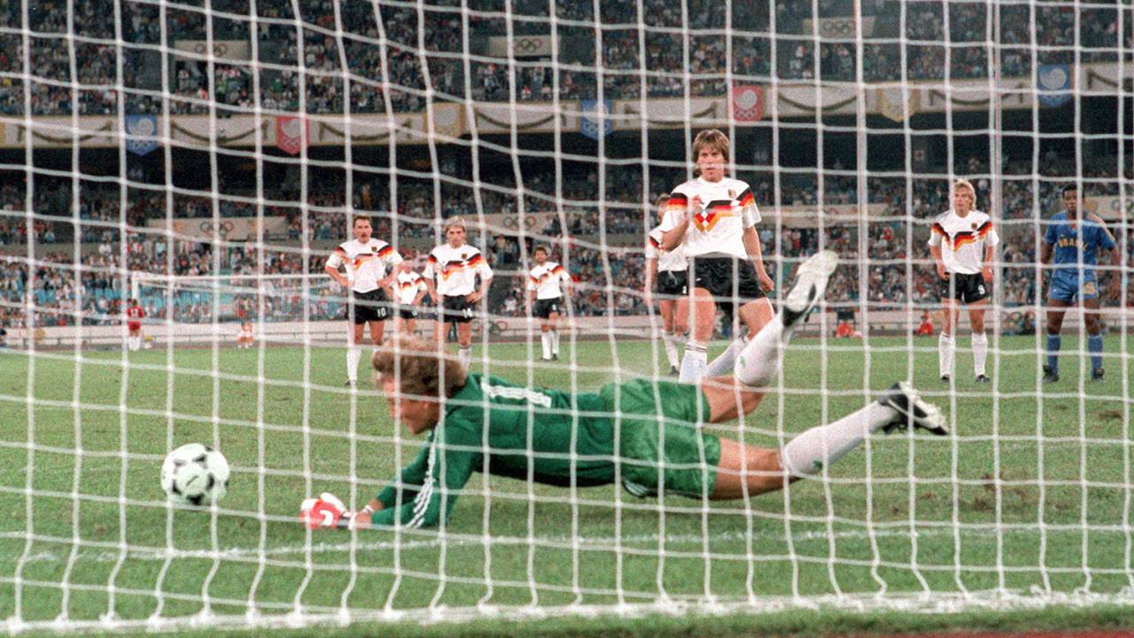 Der brasilianische Torhüter Claudio Taffarel (vorn ) pariert in der 83. Minute einen Strafstoß des deutschen Abwehrspielers Wolfgang Funkel (3.v.r). Die Fußball-Olympiamannschaft der Bundesrepublik verliert am 27.09.1988 im Olympiastadion in Seoul das Halbfinalspiel des olympischen Turniers gegen Brasilien am Ende mit 2:3 nach Elfmeterschießen. Nach der Verlängerung hatte es 1:1 gestanden. | (Photo by /picture alliance via Getty Images)
