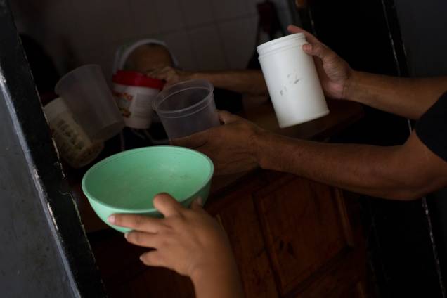 Voluntários com recipientes de plástico para enchê-los com comida para distribuir em uma igreja evangélica no centro da cidade de Caracas - Voluntários com recipientes de plástico para enchê-los com comida para distribuir em uma igreja evangélica no centro da cidade de Caracas -