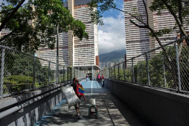 Um vendedor ambulante caminha em uma ponte de pedestres na favela de San Agustin, em Caracas - Um vendedor ambulante caminha em uma ponte de pedestres na favela de San Agustin, em Caracas -