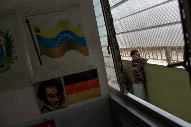 Uma criança observa pela varanda de uma escola fechada, na favela de Petare, em Caracas - Uma criança observa pela varanda de uma escola fechada, na favela de Petare, em Caracas -