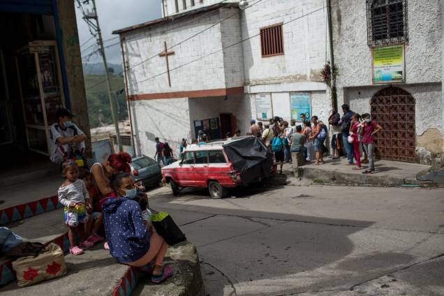 Pessoas esperam na fila do lado de fora de uma ONG na favela de Petare, em Caracas - Pessoas esperam na fila do lado de fora de uma ONG na favela de Petare, em Caracas -