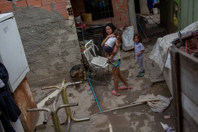 Mulher carregando sua filha de 2 anos dentro de uma favela do rio Guaire, em Caracas - Mulher carregando sua filha de 2 anos dentro de uma favela do rio Guaire, em Caracas -