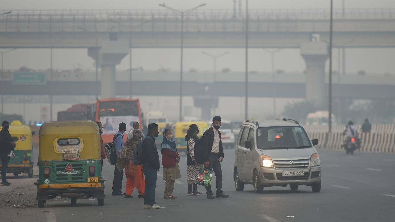 NEW DELHI, INDIA - NOVEMBER 16: People are seen wearing warm clothes as the temperature has seen a drop, on NH24, and the AQI is back in the severe category on November 16, 2021 in New Delhi, India. The air quality in the national capital plunged to the 'severe category' leaving Delhiites gasping for fresh air on Tuesday morning. The System of Air Quality and Weather Forecasting And Research (SAFAR), informed that the air quality index in the city is at 499 thereby being in the 'severe category.' (Photo by Raj K Raj/Hindustan Times via Getty Images)