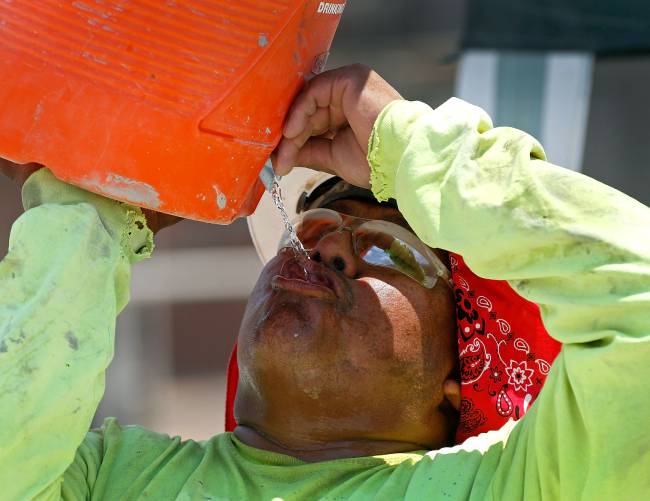 Phoenix Boils In Near-Record Heat Wave Trabalhador se hidrata durante onda de calor em Phoenix, nos Estados Unidos