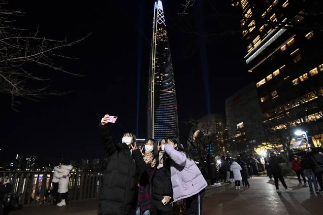 Mulheres tiram selfie em frente ao prédio Lotte World pouco antes da virada em Seul, na Coreia do Sul Mulheres tiram selfie em frente ao prédio Lotte World pouco antes da virada em Seul, na Coreia do Sul