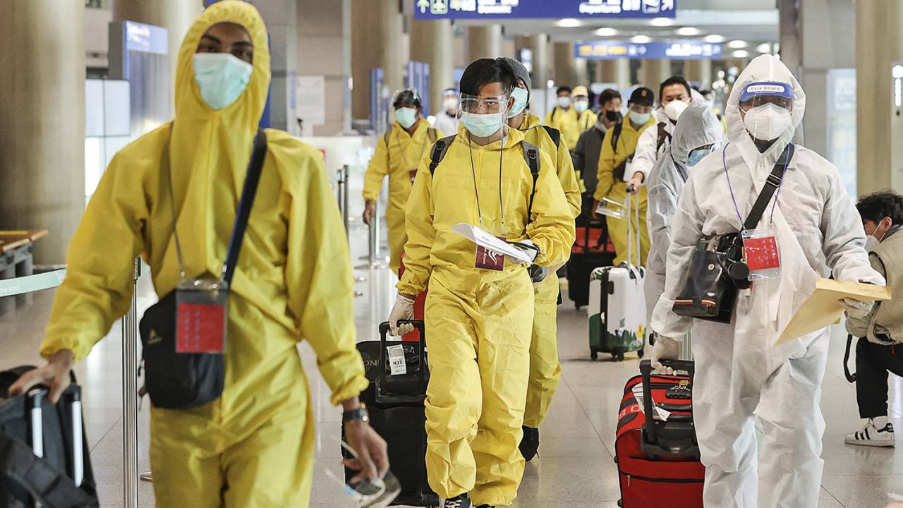 PROTEÇÃO - Figurino de viagem: na Coreia do Sul, passageiros usam roupa especial para afastar o risco de infecção pela cepa -
