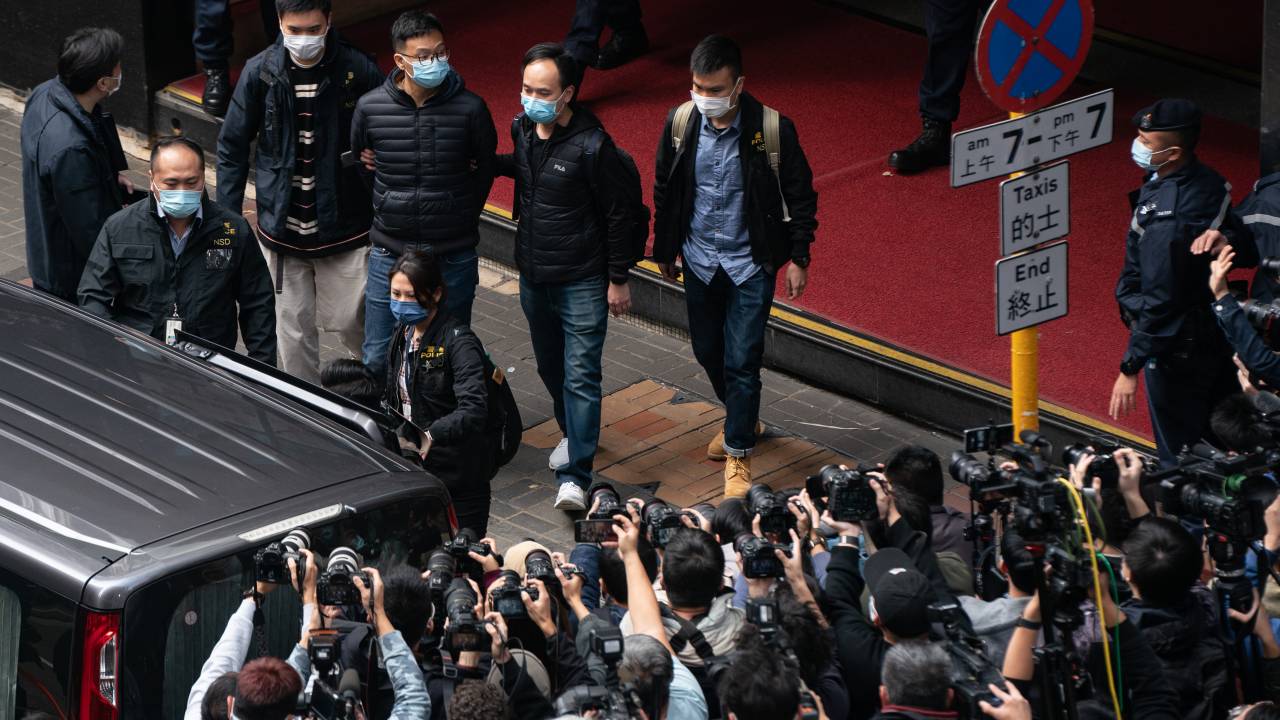 HONG KONG, CHINA - DECEMBER 29: Stand News Editor-in-Chief Patrick Lam is brought is brought into a vehicle after police searched the premises at the independent news outlet office on December 29, 2021 in Hong Kong, China. Editors, board members and a pop singer were arrested in the early morning sweep as 200 officers raided the office. (Photo by Anthony Kwan/Getty Images)