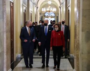 Presidente dos EUA, Joe Biden, caminha no Capitólio junto ao líder da maioria democrata no senado, Chuck Schumer, e presidente da Câmara, Nancy Pelosi. 06/01/2022