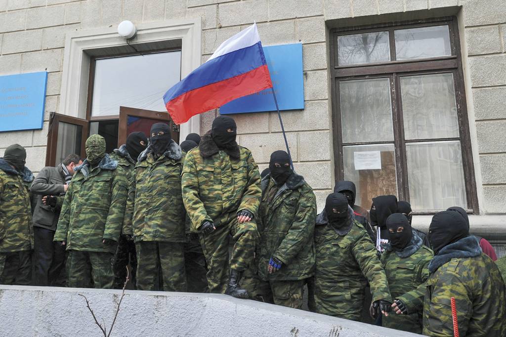 CRIMEIA-OCUPAÇAO-RUSSA-2014.jpg COMEÇO - Mascarados com a bandeira russa na invasão da Crimeia, em 2014: a anexação foi definitiva -