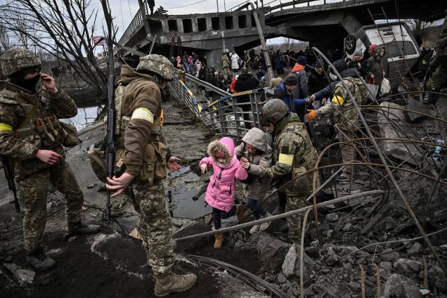 Pessoas atravessam uma ponte destruída ao evacuar a cidade de Irpin, ao noroeste de Kiev - Pessoas atravessam uma ponte destruída ao evacuar a cidade de Irpin, ao noroeste de Kiev -