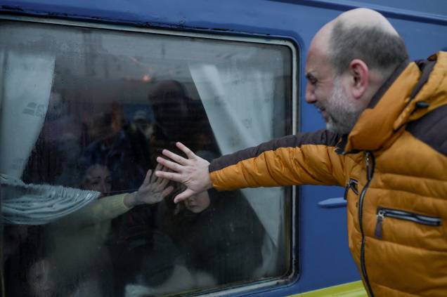Um pai chora ao se despedir de sua família em frente a um trem de evacuação na estação central de trem de Odessa - Um pai chora ao se despedir de sua família em frente a um trem de evacuação na estação central de trem de Odessa -